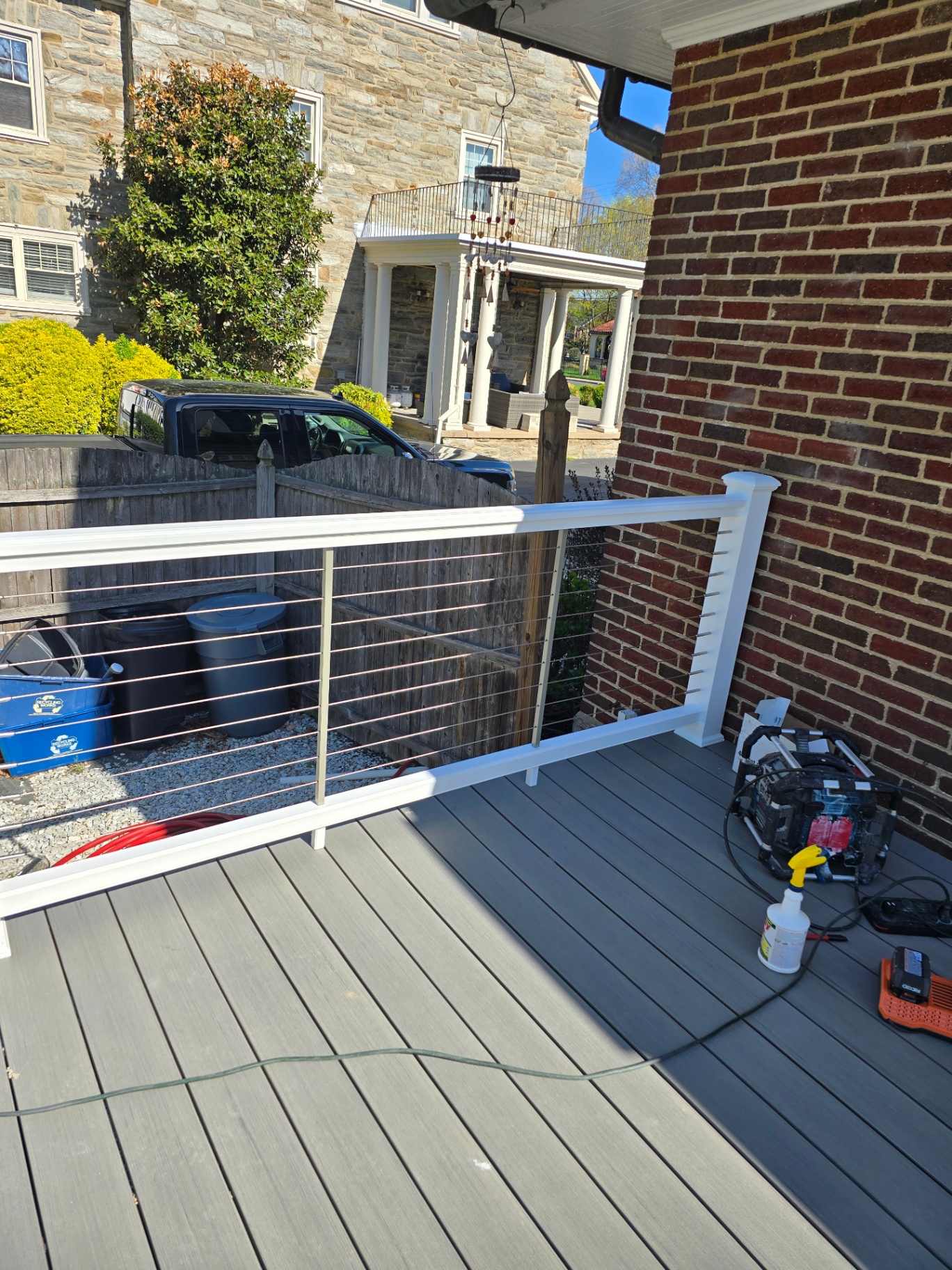 Corner of composite deck with cable railings and view of neighborhood
