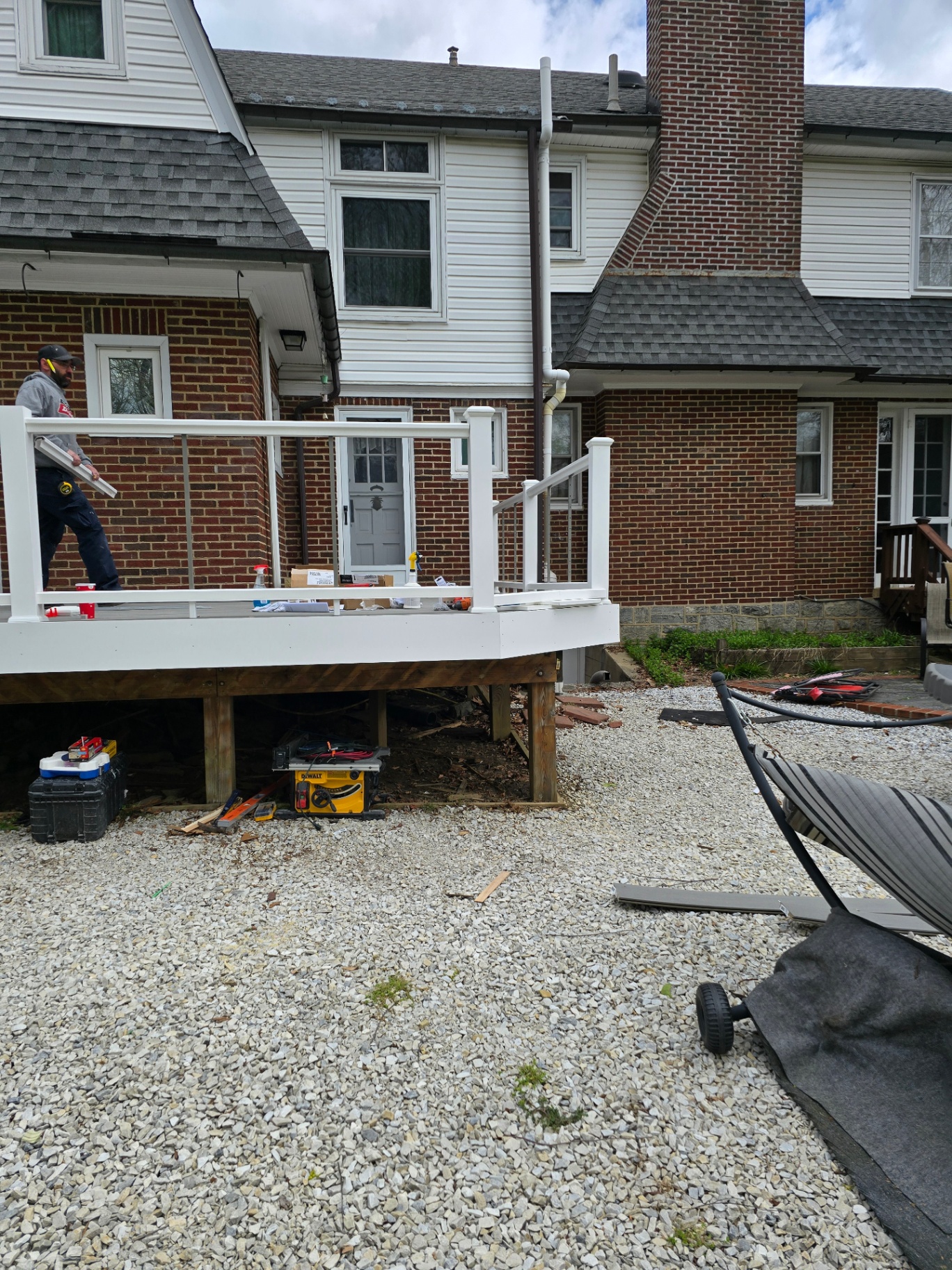 Composite deck with white cable railings under construction